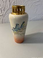 Front view showing bird artwork, ombre glaze, gilt collar