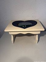 Full view of footstool showing heart cutout and leg design