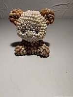 Front view of seashell-covered teddy bear figurine