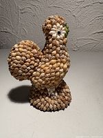 Front-side view of seashell rooster showing body, tail and felt base