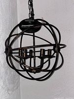 Full view of spherical chandelier hanging from chain