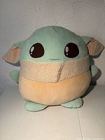 Front view of Grogu plush showing overall shape, colors, and condition