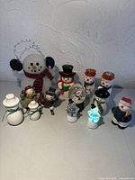 Group view of entire lot of snowman decorations on tabletop