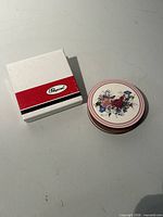Box and stack of round floral coasters top view