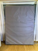 Front view of gray upholstered top surface of queen box spring