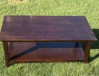 Full view of coffee table front and lower shelf on grass