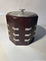Front view of octagonal wooden ice bucket with pewter lid and accents
