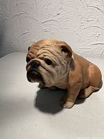 Front three-quarter view of seated bulldog figurine showing facial detail and overall form