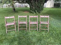Front view of all four matching folding chairs on lawn