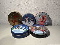 Group of five holiday tins front view