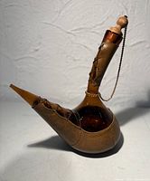 Full profile of amber glass decanter with leather wrap, stopper, chain visible