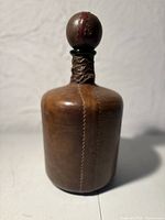 Full view of decanter front showing leather covering and stitched seam