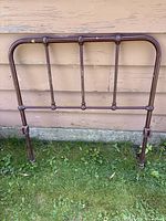 Full view of metal twin headboard standing against wall