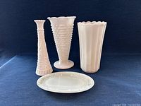 Group shot of four milk glass pieces: two vases, bud vase, dresser tray