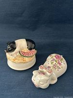 Both porcelain pig items side by side on blue background