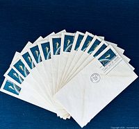 Fan display of all 13 envelopes showing stamps