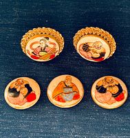 Front view: pair of clip-on earrings above loose ceramic buttons