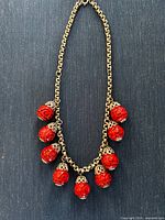 Full view of necklace showing chain and all carved cinnabar beads