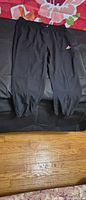 Full view of black adidas jogger pants laid flat