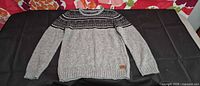 Front view of grey patterned Buffalo sweater laid flat