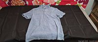Front view of light blue terry polo shirt laid flat