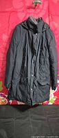 Front view of dark navy Columbia hooded parka hanging