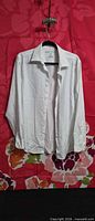 Front view of white Perry Ellis long-sleeve button-up shirt on hanger