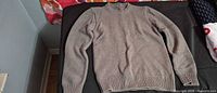Front view of taupe knit crew neck sweater