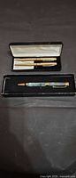 Both presentation boxes open showing two Stratford gold-tone pens and one green marbled pen