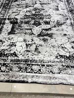 Full view of distressed black, grey, white rug