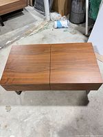 angled view showing walnut veneer top and silver sled legs