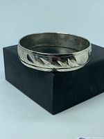 Front view of sterling silver bangle displaying diagonal cut-out design