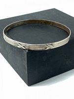 Full view of sterling silver grooved bangle resting on box