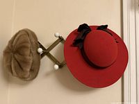 Both hats hanging on expandable peg rack