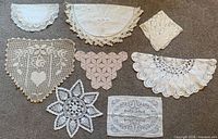 Group view of all eight lace pieces arranged on floor