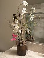 Full view of tall faux orchid arrangement on countertop