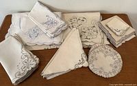 Assortment of embroidered linen napkins, doilies and handkerchiefs spread on table