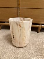 Front view of cylindrical faux marble waste basket