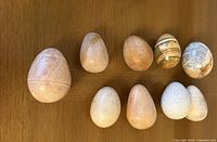 All ten carved stone eggs displayed on wooden surface