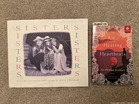 Front covers of Sisters hardcover and The Art of Hearing Heartbeats paperback