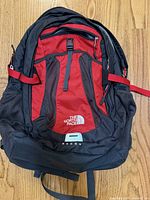 Front view showing red panel, mesh pockets, logo and model name