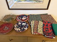 Overall lot view on dresser showing four plates and stack of napkins