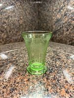 Front view of green uranium glass vase showing floral pattern