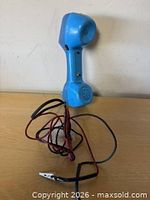 Side view of blue Harris Dracon handset with coiled test leads