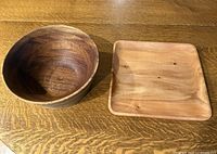 Top view of wooden bowl and square platter side by side