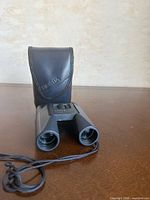 Front view of binoculars and pouch showing branding and lens openings