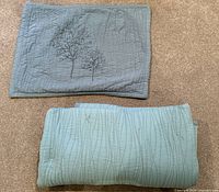 Bedspread folded and pillow sham displayed showing matching quilt pattern