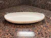 Full side profile showing oval milk glass dish and sawtooth rim