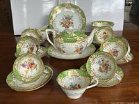 Group view showing cups, saucers, plates, teapot, milk jug and slop bowl