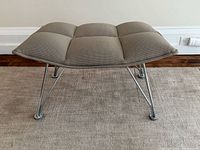 Front view of taupe upholstered Jehs+Laub ottoman on chrome frame
